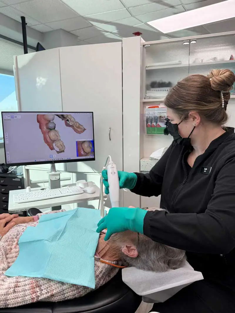 A female patient happily waiting in a dental chair for her dentist to begin her routine dental exam